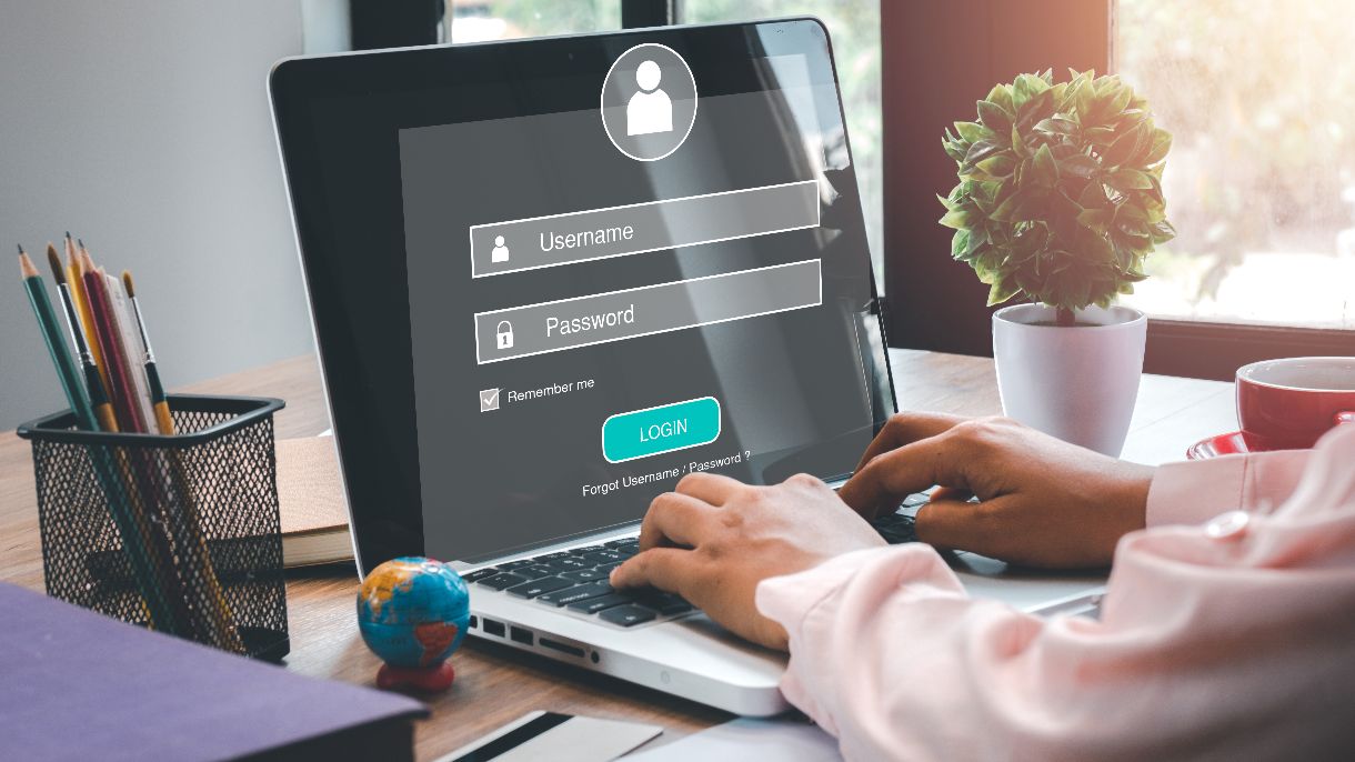 Login, @iStock.com/Maxxa_Satori Person gibt Login und Passwort am Laptop ein