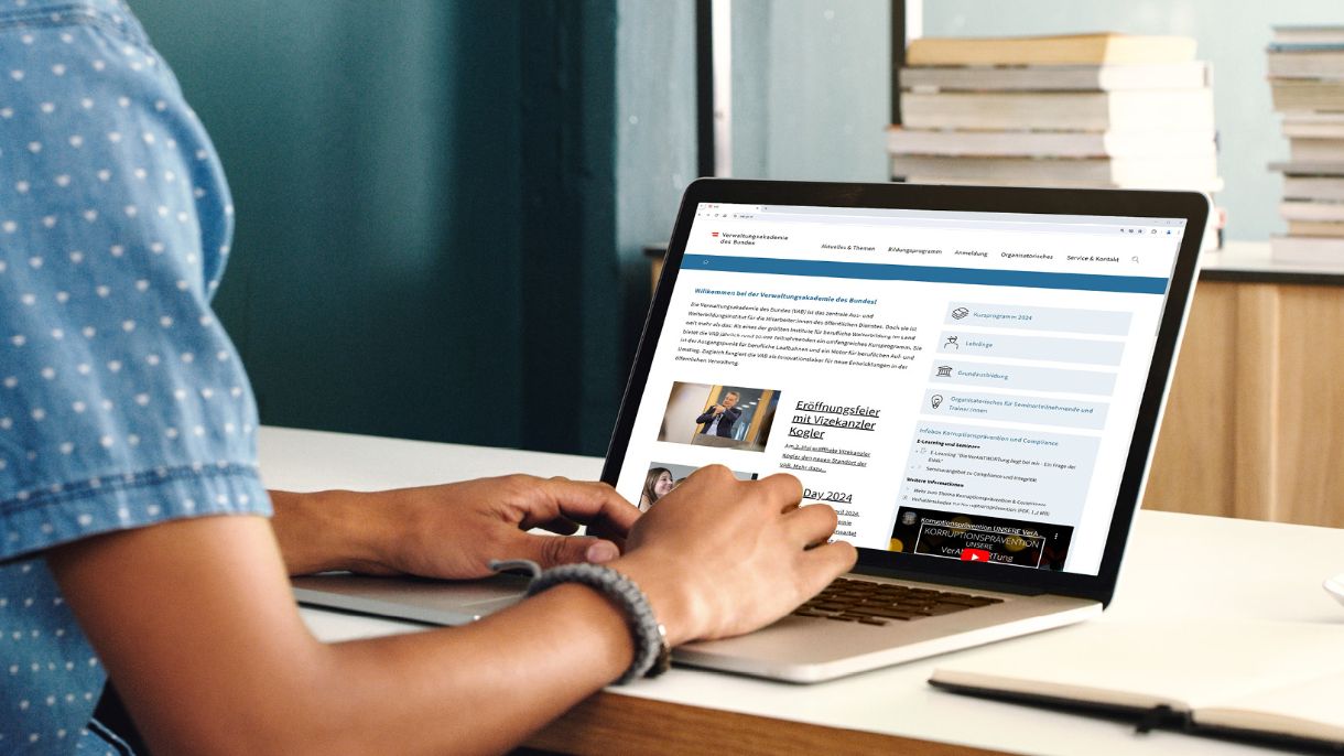 Verwaltungsakademie, @Verwaltungsakademie des Bundes - iStock.com/shapecharge Person am PC hat die Webseite der Verwaltungsakademie des Bundes auf